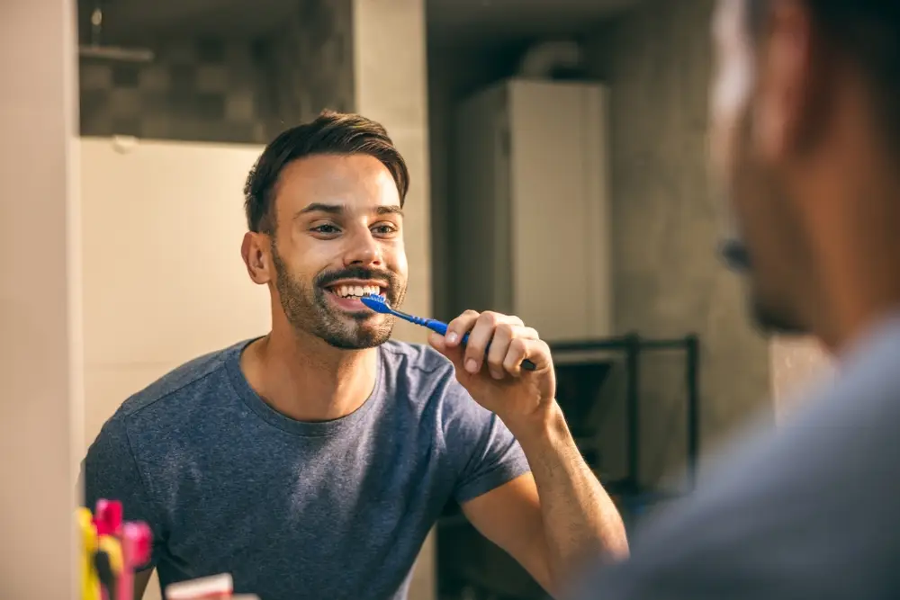 Man brushing teeth at home, promoting good oral hygiene habits