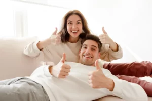 Happy couple smiling and giving thumbs up, representing positive dental experience with Top-notch dentist in Spirit Lake IA