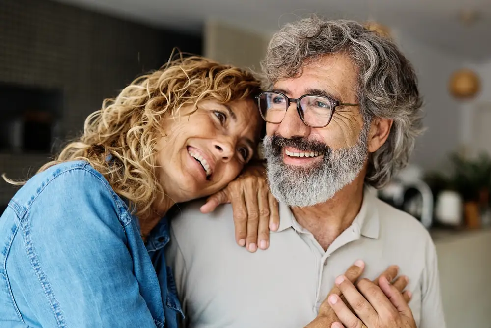 Senior couple smiling, representing long-term dental health and care with Dental Crowns in Spirit Lake IA